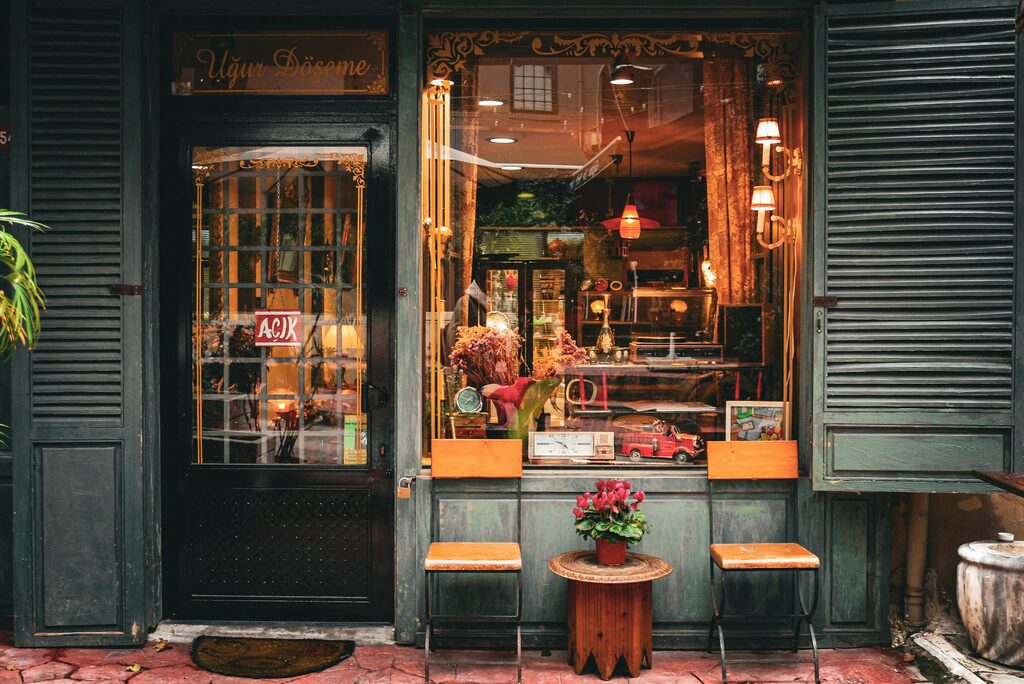 木のスツールと花を飾った、ヴィンテージ調の店舗の外観